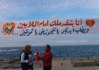 «يا تتجوزيني يا تموتيني».. صحفي يُفاجئ زميلته بطلب الزواج في لافتة بكورنيش الإسكندرية