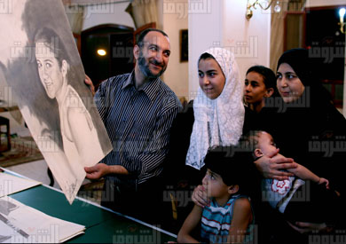 أسرة الشهيد عيسى عصام تتأمل إحدى لوحاته - تصوير : روجيه أنيس