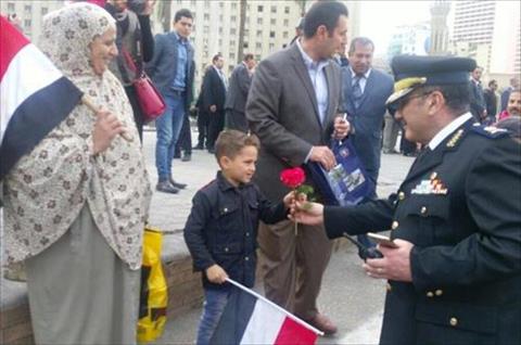 أمن القاهرة يوزع هدايا تذكارية وورود على المواطنين بالميادين في ذكرى الثورة