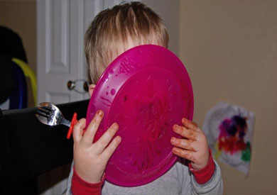 طفل يأكل من طبق بلاستيك