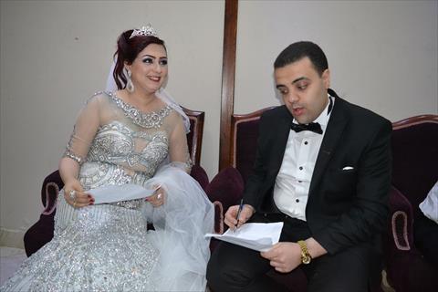 عروسان يوقعان استمارة عشان تبنيها