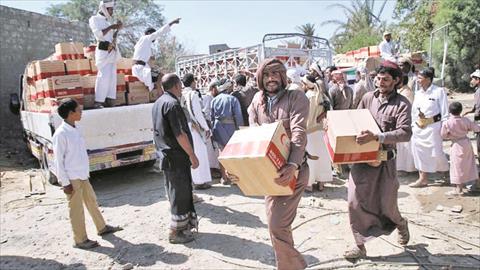 يمنيون يتسلمون مساعدات من الهلال الأحمر الإماراتى