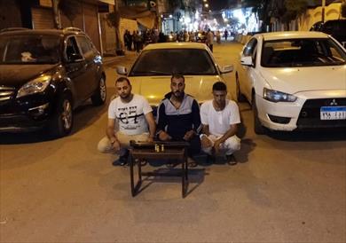 المتهمون أمام السيارات المضبوطة