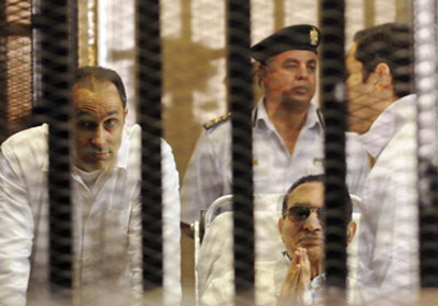 الرئيس السابق حسني مبارك ونجليه داخل قفص الاتهام في جلسة سابقة