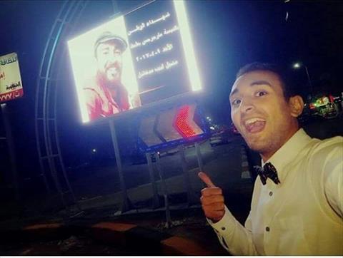 الشاب يلتقط سيلفي مع صورة الشهداء