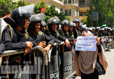 مصرية تحمل لافتة تشيد بالعلاقات مع السعودية وأمامها رجال الأمن أمام السفارة بالجيزة تصوير - هبة الخولى