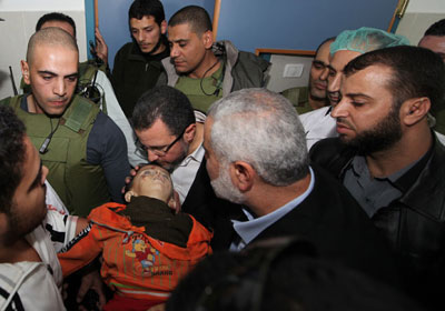 قنديل وهو يحمل طفلا شهيدا في غزة