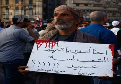 مواطن فى ميدان التحرير يرفع لافتة للتضامن مع الشهداء تصوير  محمد نوهان