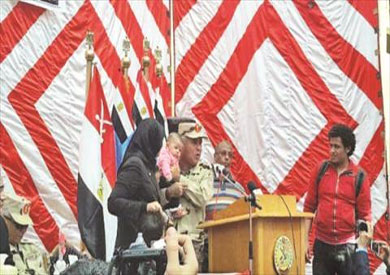 قائد حرس الحدود حاملا طفلة الشهيد