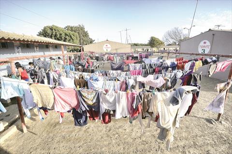 عمال في إحدى مزارع الطماطم بوادي كينتين المكسيكي يستغلون عطلة عيد العمال في غسل الملابس