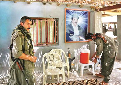 مقاتلين من الـ"بي بي كا" ومن خلفهم الزعيم الكردي عبد الله أوجلان فى أحد معسكراتهم - أ ف ب