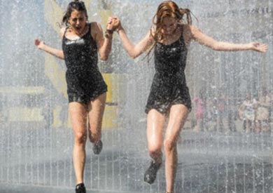 فتاتان تلهوان في مياه نافورة في لندن لتخفيف الاحساس بالحرارة