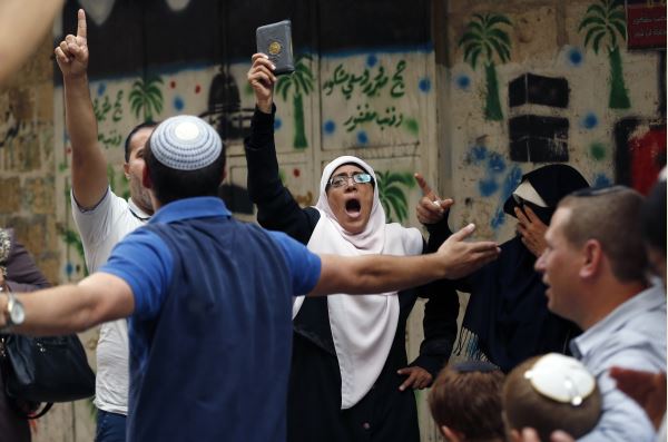 فلسطنية ترفع المصحف وتصرخ في وجه الإسرائيليين- أ.ف.ب